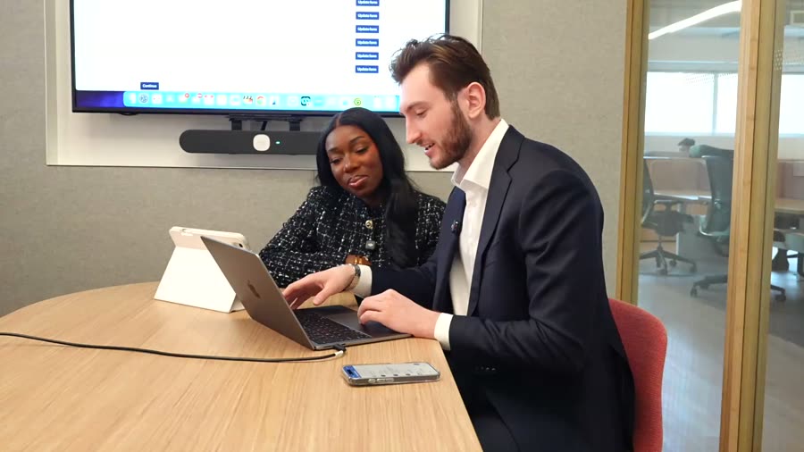 Two professionals collaborating over a laptop