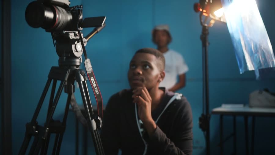 Videographer adjusting a camera on a tripod